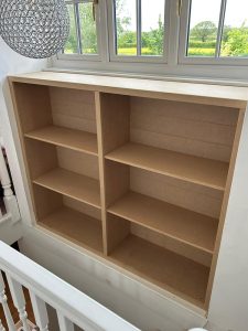 Bespoke Stairwell Storage. This custom-built stairwell shelving unit was designed and handcrafted by the Creative Finish Carpentry Division, creating valuable storage space while maintaining a clean and seamless appearance.