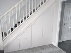 Understairs Storage Transformation. Making the most of every inch of space. This bespoke understairs storage solution was designed, manufactured and installed by the Creative Finish Carpentry Division, transforming an unused area into a clean, practical and seamless feature that blends perfectly with the existing interior.