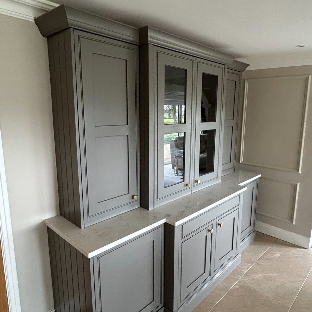 From a standard fitted unit to a fully bespoke feature piece. This project was completely reworked by Creative Finish Carpentry — introducing pocket doors, bespoke glass panel sections, and refined proportions to elevate both function and design. Once the structure was perfected, the entire unit was professionally sprayed in Farrow & Ball “Moles Breath 276” using our factory-grade 2K system. The result is a seamless, durable finish with depth, richness, and a true furniture-quality look — built to last and designed to stand out.